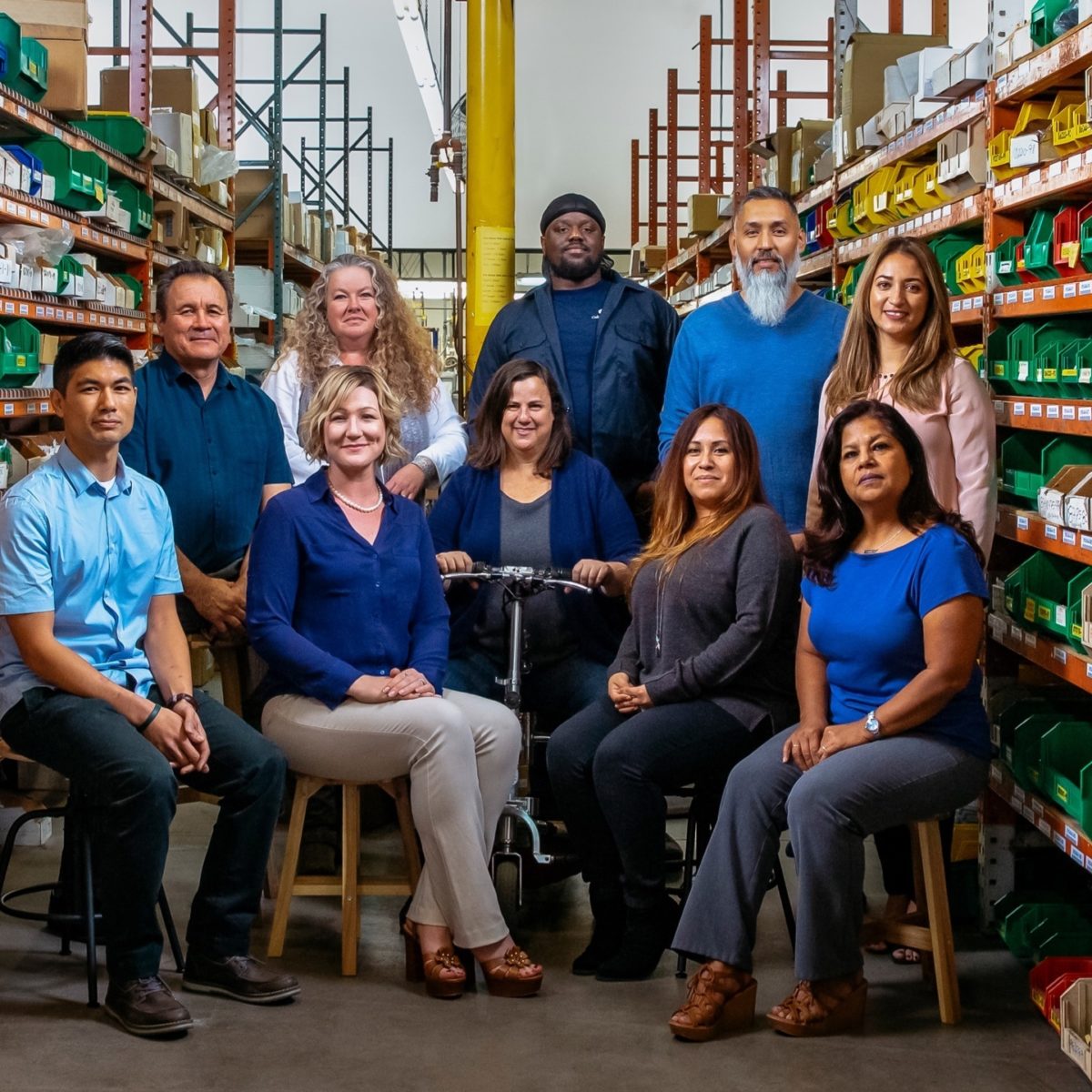 group of California Faucets employees surrounded by warehouse shelving